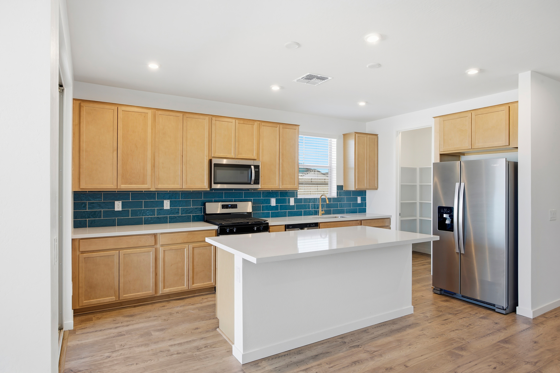 kitchen with wood-like flooring, terlingua countertops, and stainless-steel appliances