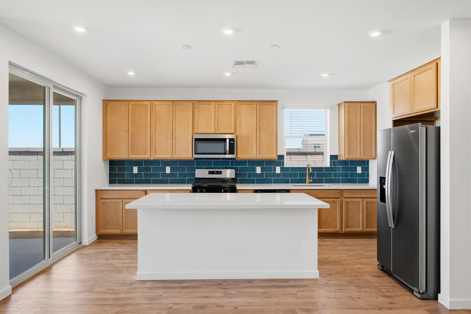 kitchen with wood-like flooring, terlingua countertops, and stainless-steel appliances