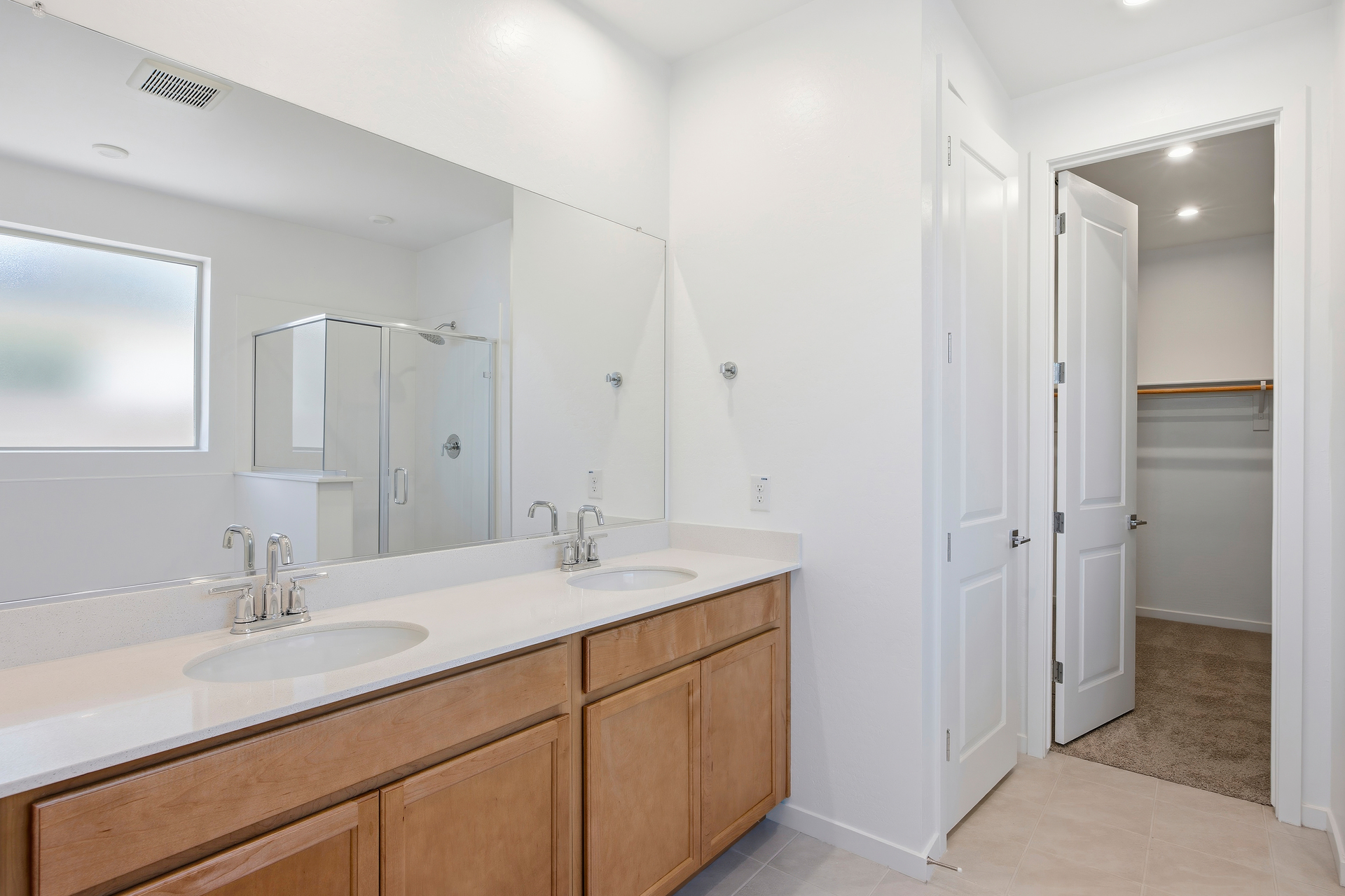 spacious bathroom with a light brown cabinet, walk-in shower, and a soaking tub