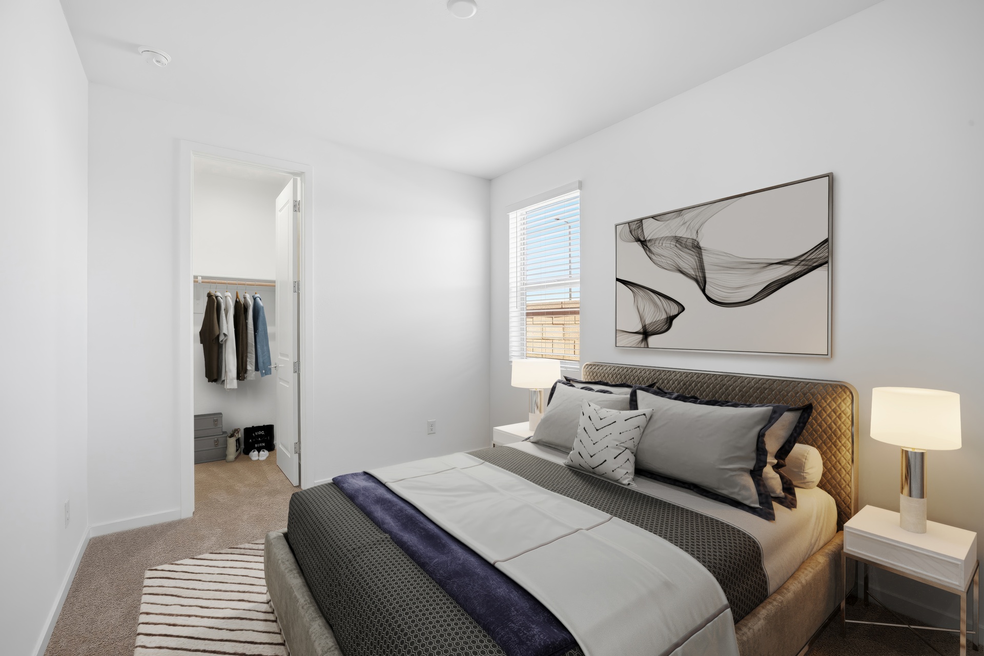bedroom with a large bed with black bedsheets and artwork on the wall
