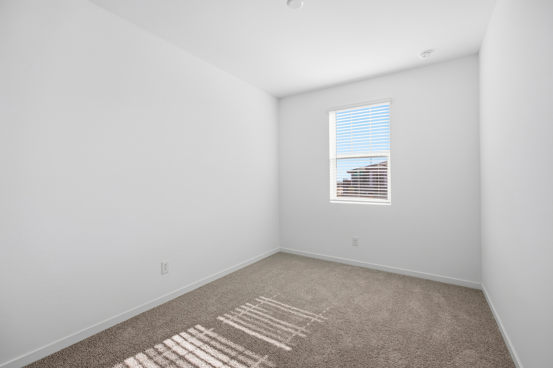 bedroom with light brown carpet and a window for natural light
