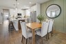 dining room with wood flooring, green accent wall, dining room table with chairs, and a window