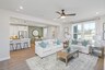 great room with white sofas, wood flooring, accent furniture, and large windows