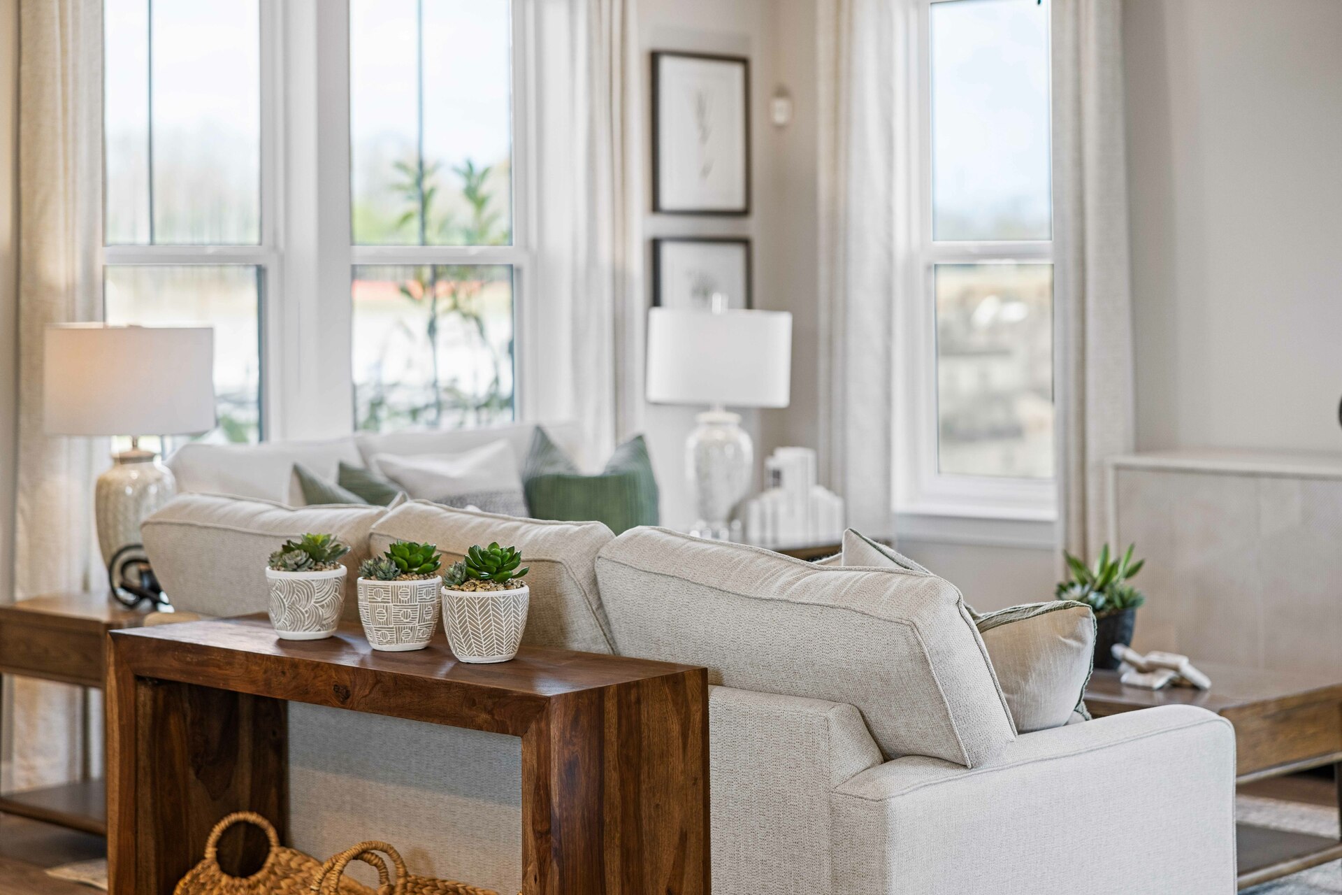 great room with white sofas, wood flooring, accent furniture, and large windows