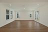 great room with wood floors, white walls and large windows
