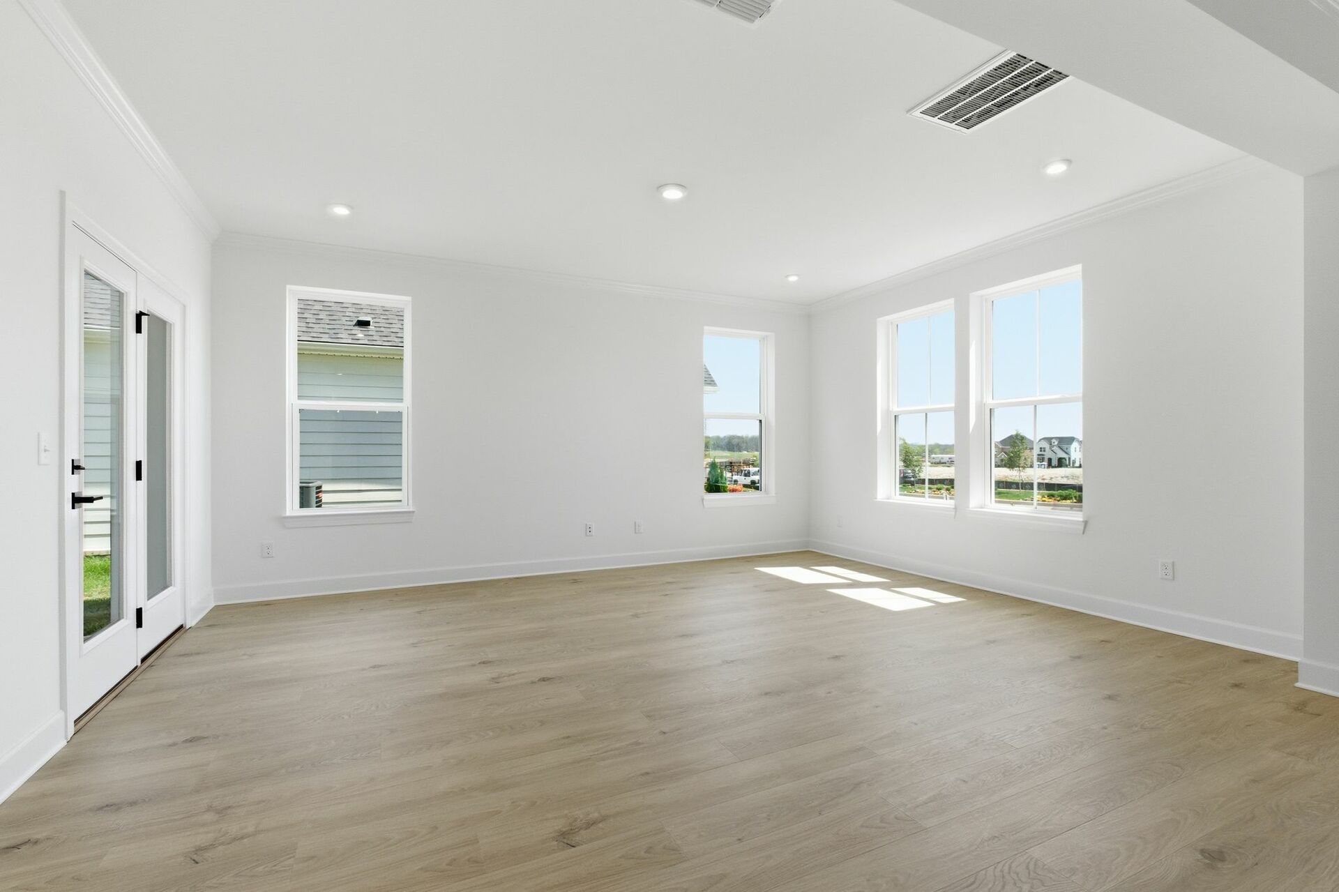 great room with wood flooring and large windows