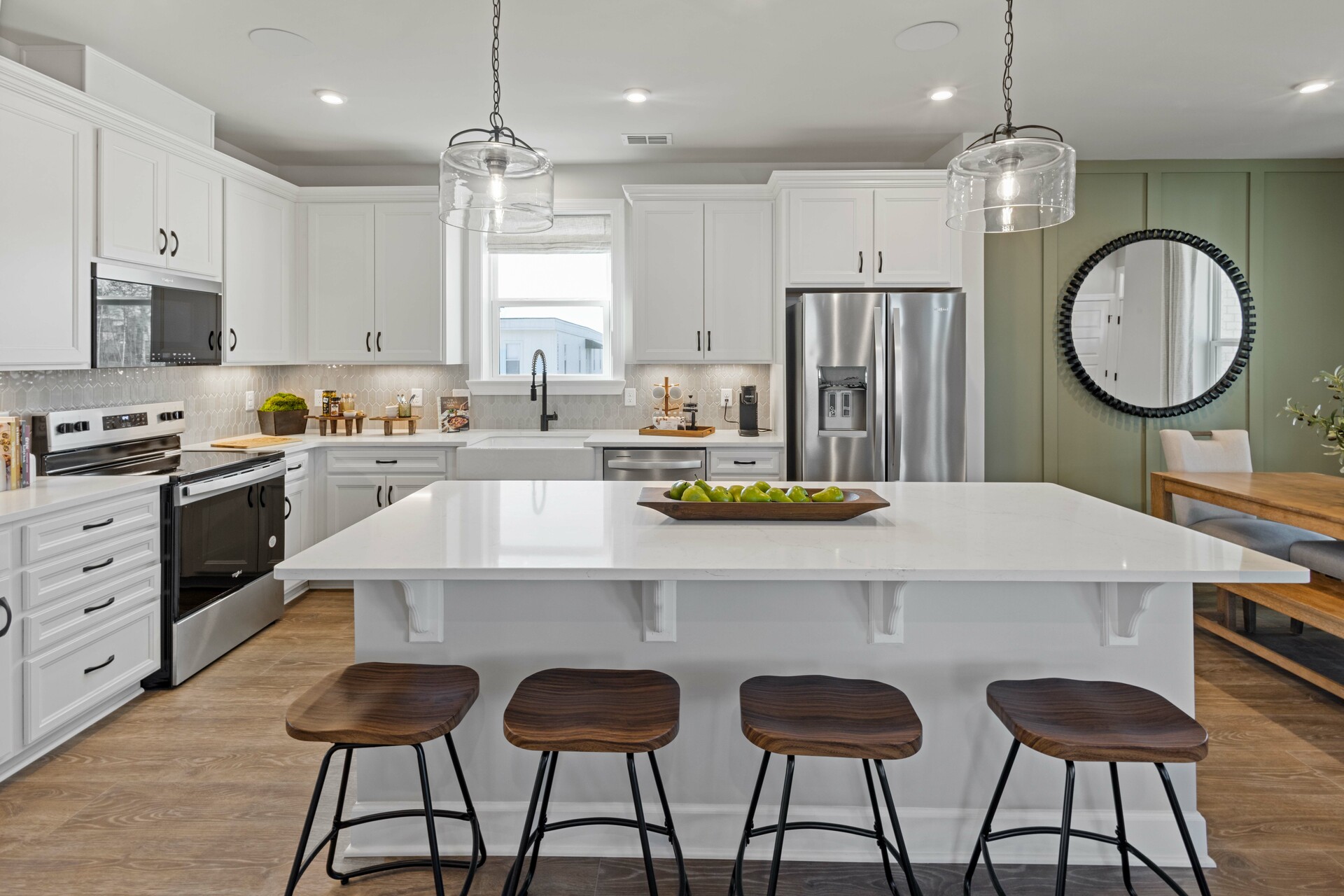 kitchen with white cabinets, white countertops, a window over the sink, and a large island