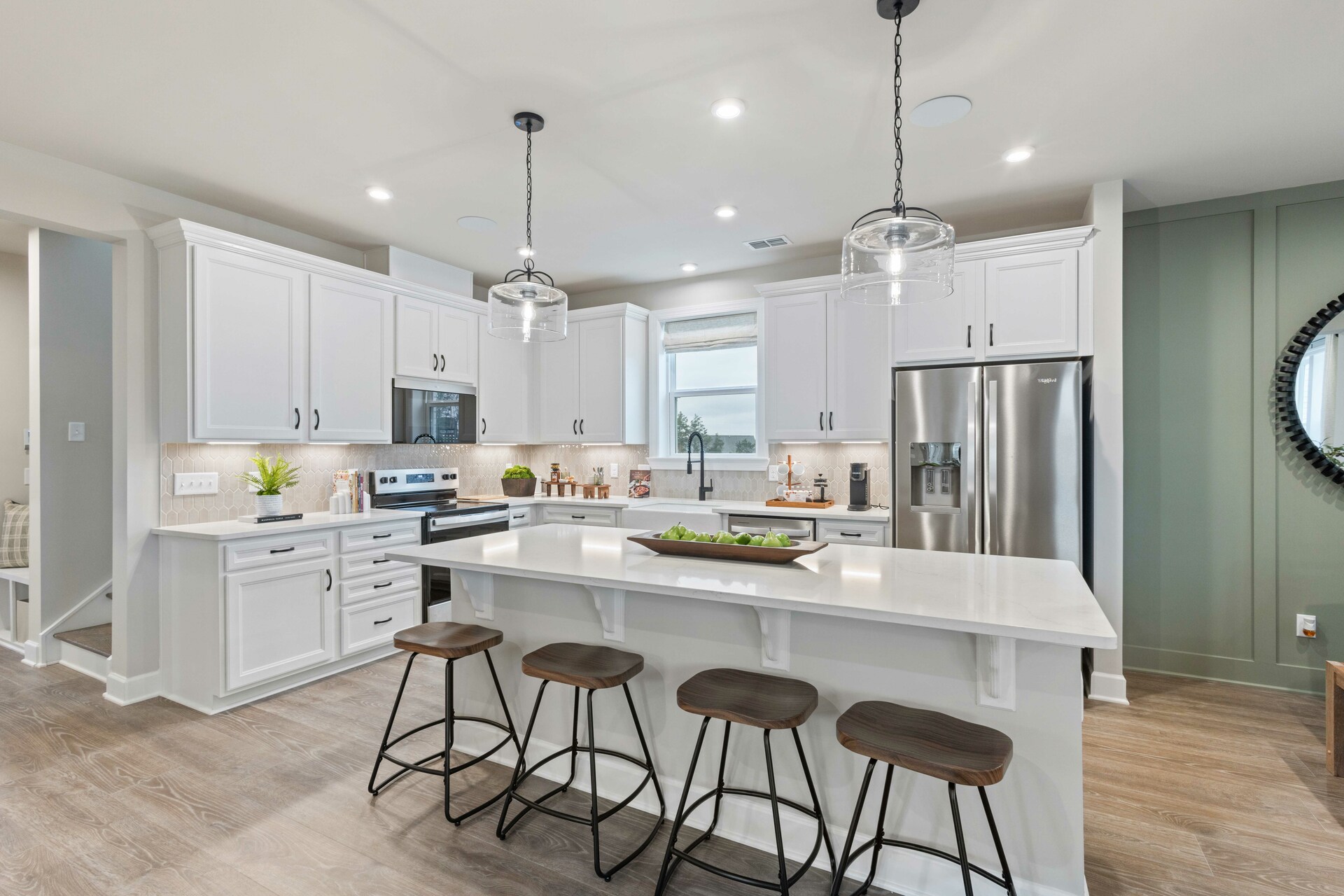 kitchen with white cabinets, white countertops, a window over the sink, and a large island