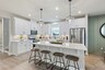 kitchen with white cabinets, white countertops, a window over the sink, and a large island