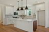 kitchen with white cabinets, island with wood cabinets, and black hardware