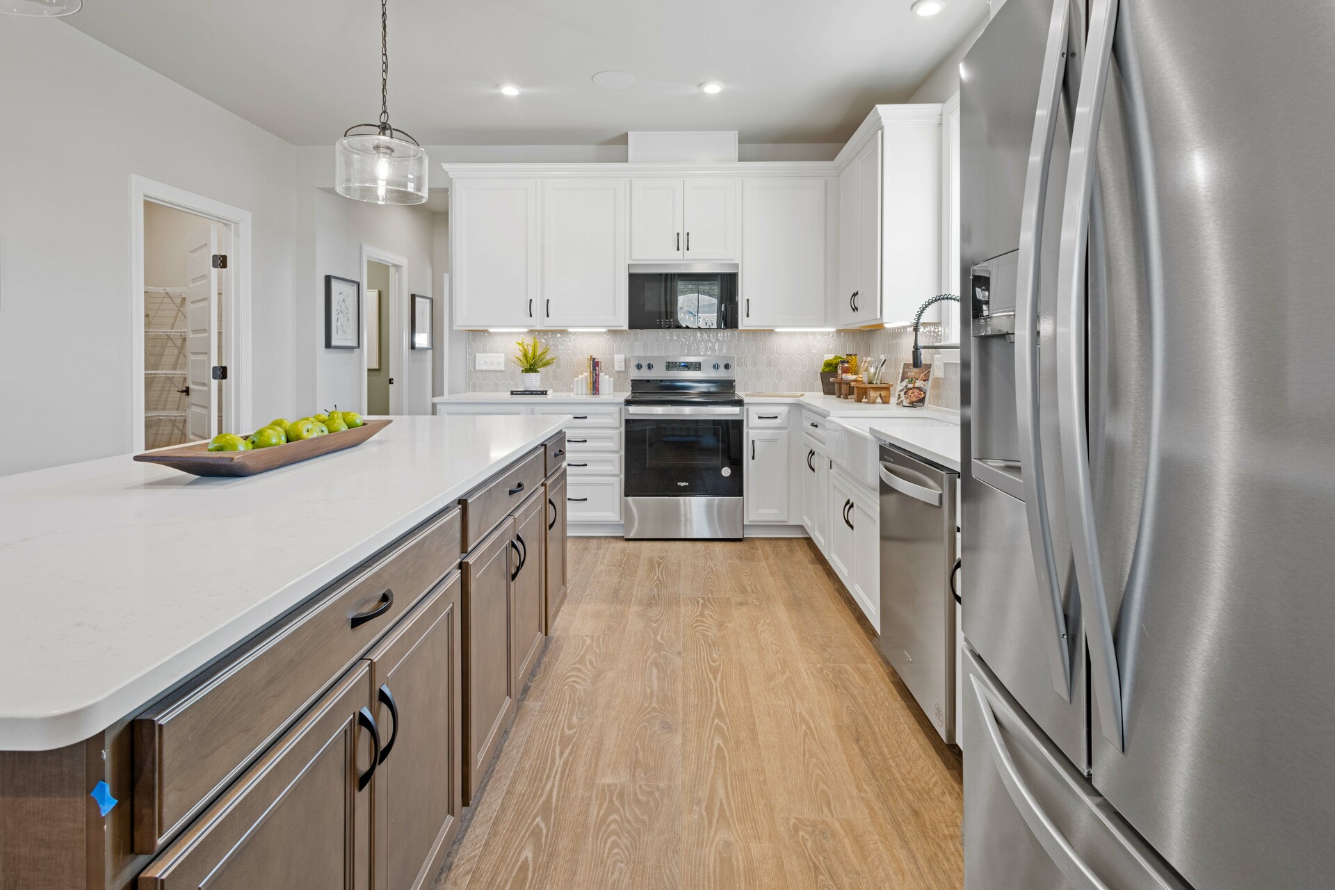 kitchen with white cabinets, white countertops, a window over the sink, and a large island