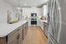 kitchen with white cabinets, white countertops, a window over the sink, and a large island