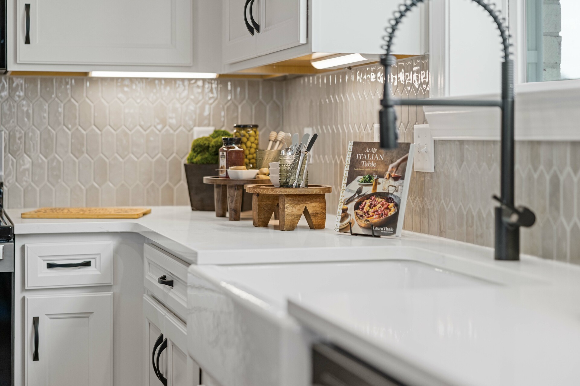 kitchen with white cabinets, white countertops, a window over the sink, and a large island