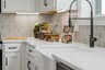 kitchen with white cabinets, white countertops, a window over the sink, and a large island