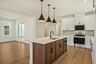 kitchen with white cabinets, island with wood cabinets, and black hardware