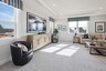 loft space with carpet flooring, large sofa, tv, large windows, and a tray ceiling