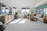 loft space with carpet flooring, large sofa, tv, large windows, and a tray ceiling