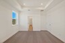 primary bedroom with carpet, large windows, and tray ceiling