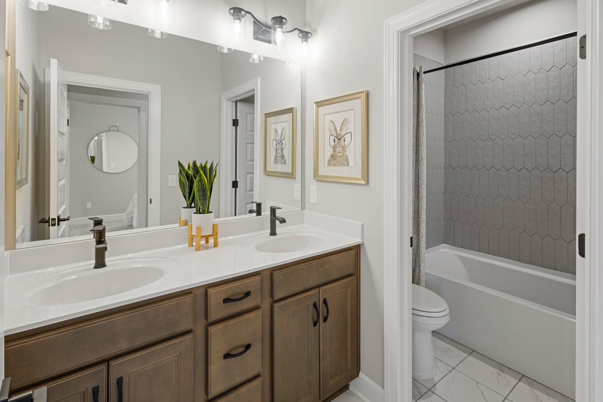 secondary bathroom with wood cabinets, white countertops, and a shower and tub combination