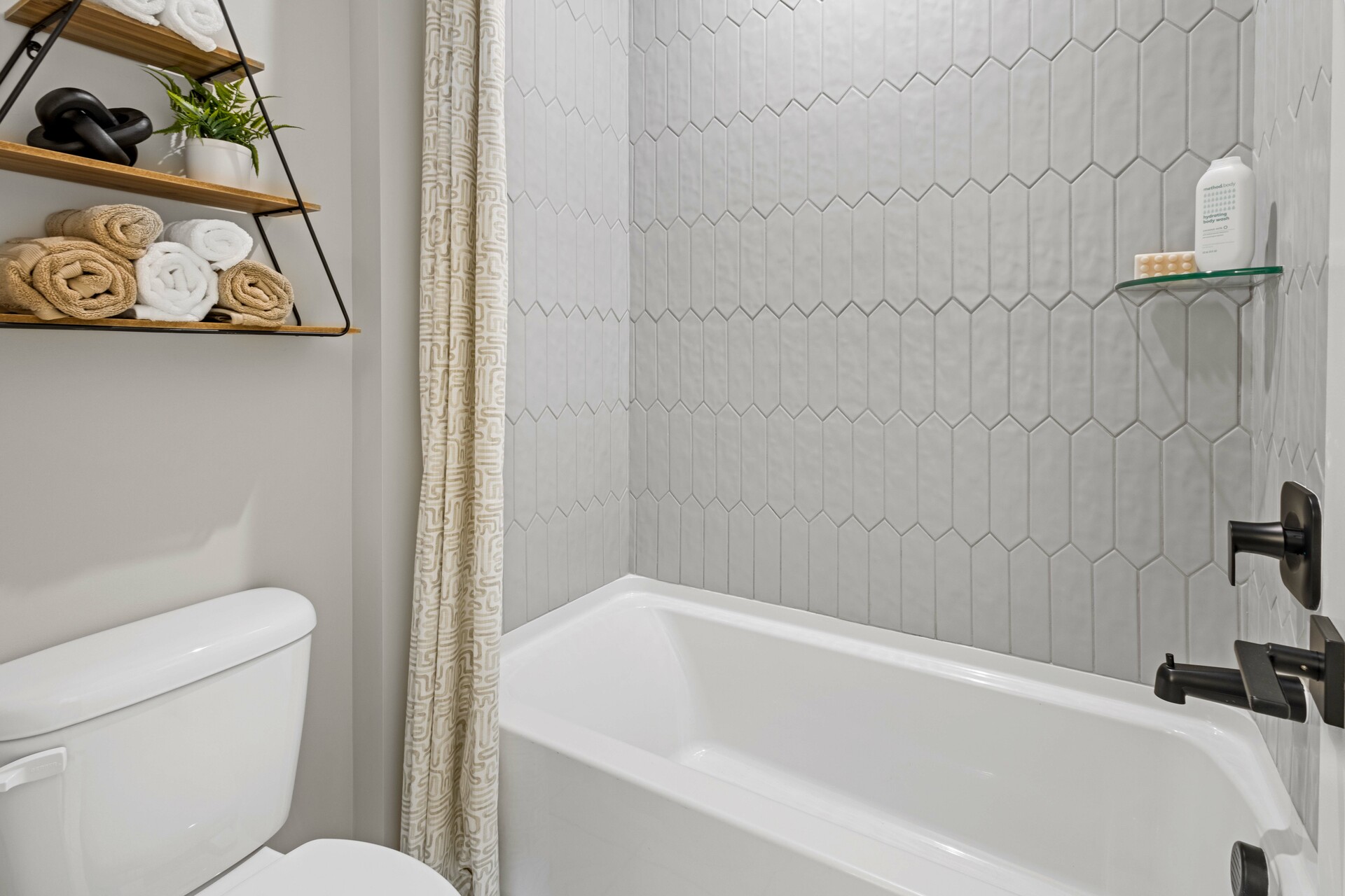 secondary bathroom with wood cabinets, white countertops, and a shower and tub combination