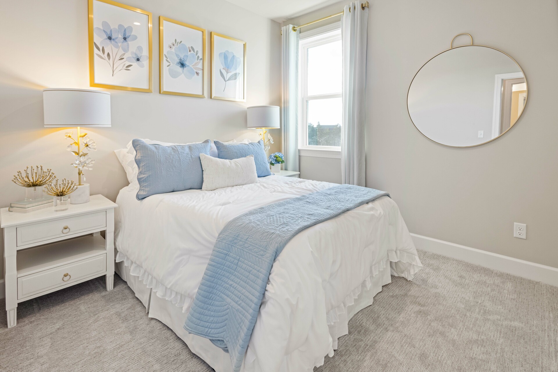 secondary bedroom with bed, nightstands, light blue accents, and a large window
