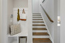 staircase with wood treads, a valet bench, and wall hooks