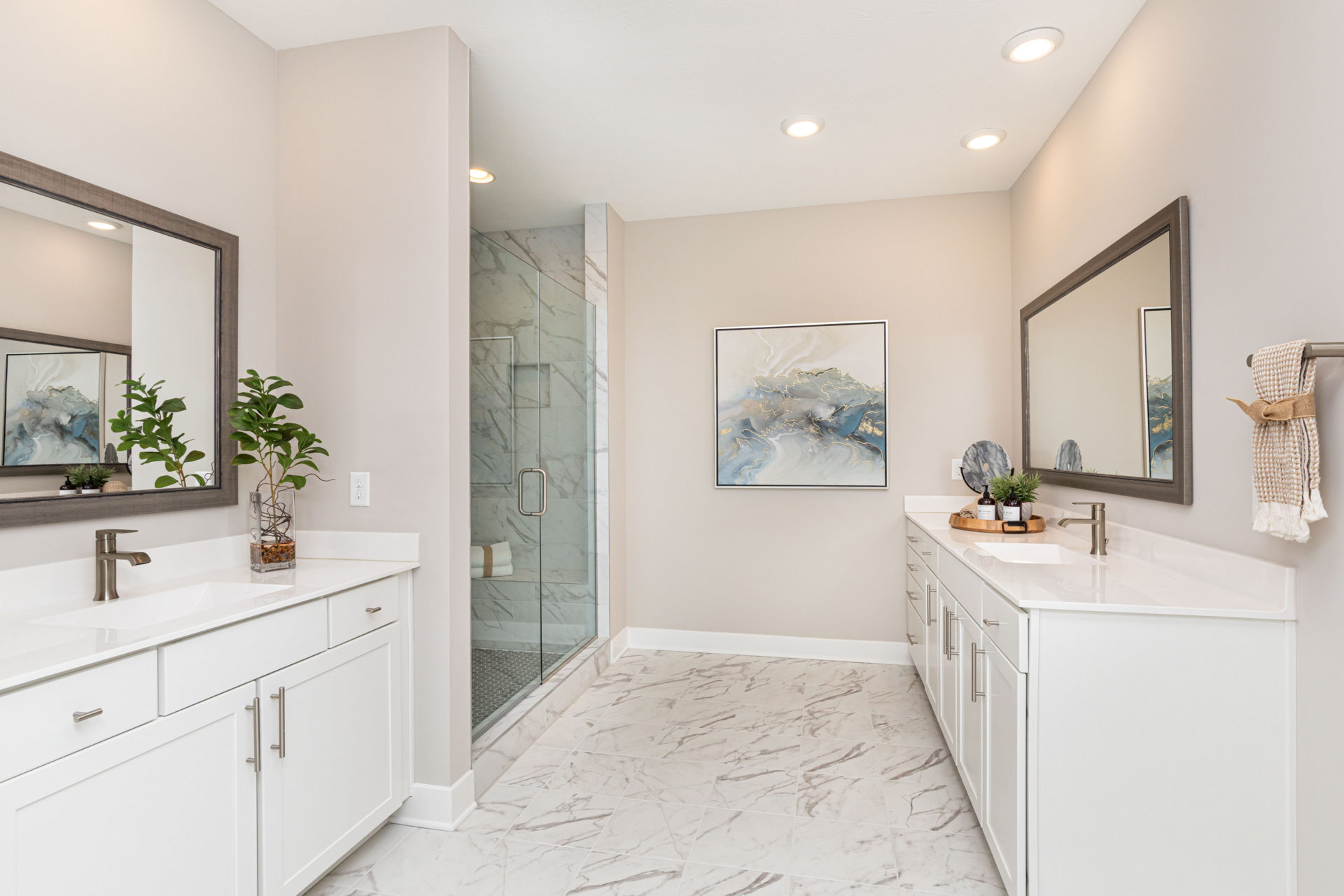 primary bathroom with white counters, marble flooring, and glass shower