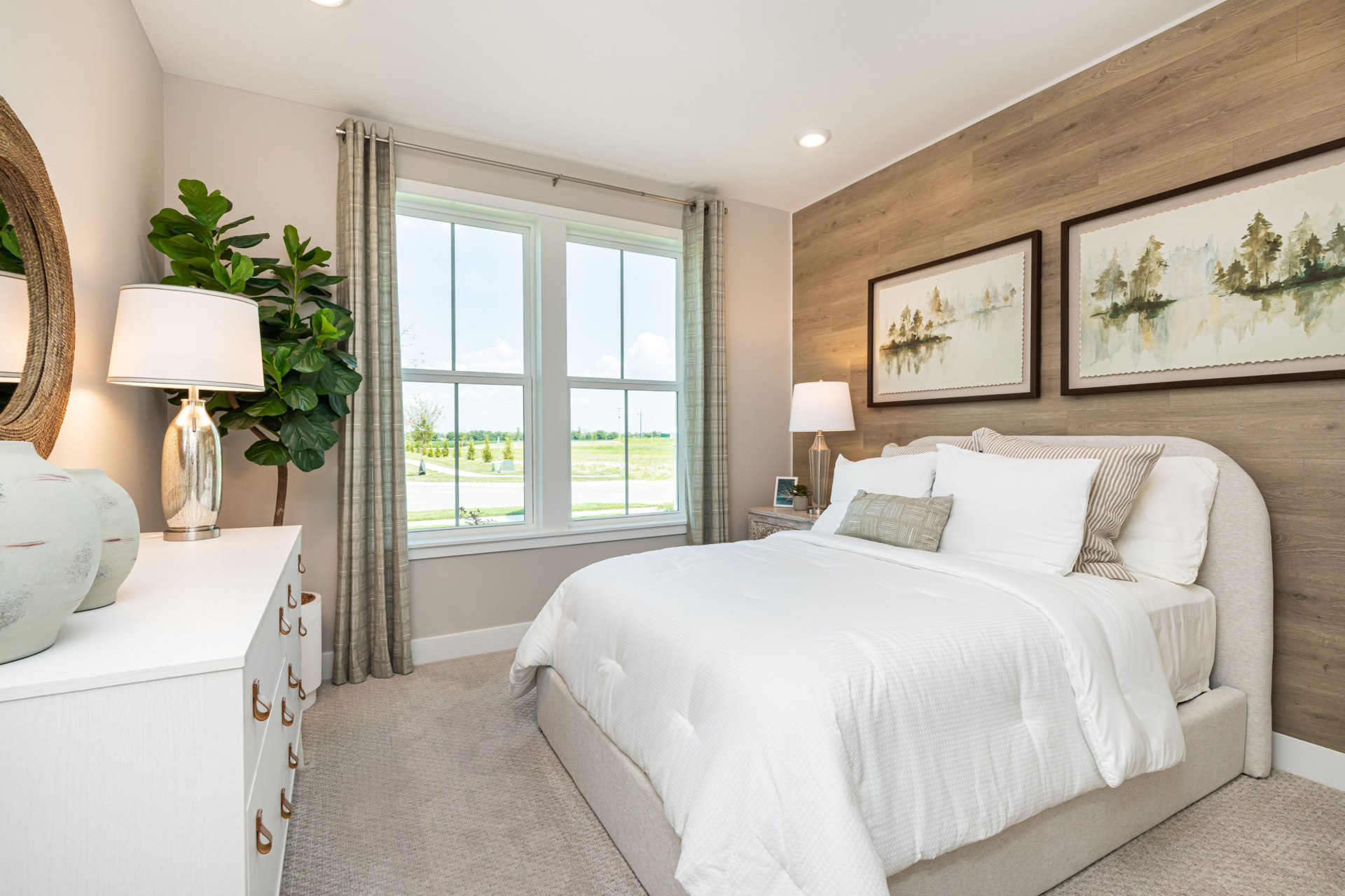 primary bedroom with king-sized white bed and wooden accent wall