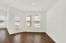 dining area with brown plank flooring and white walls looking out to the back patio