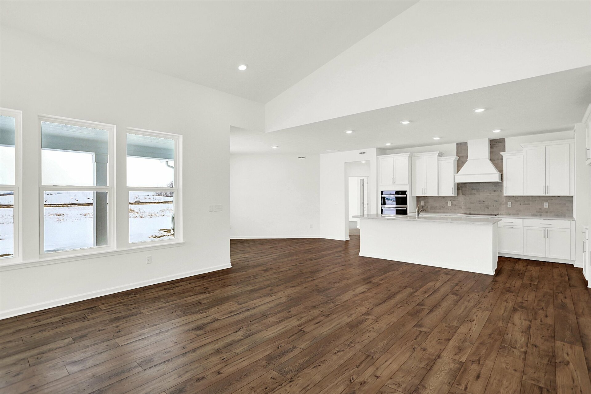 open-concept two-story great room that looks into the kitchen and dining area