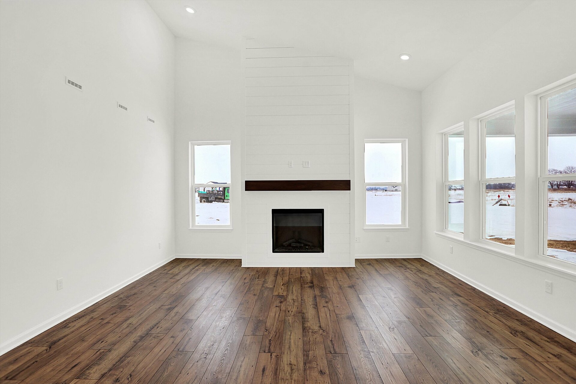 two-story great room with fireplace that has shiplap detail