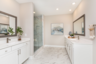 primary bathroom with white counters, marble flooring, and glass shower