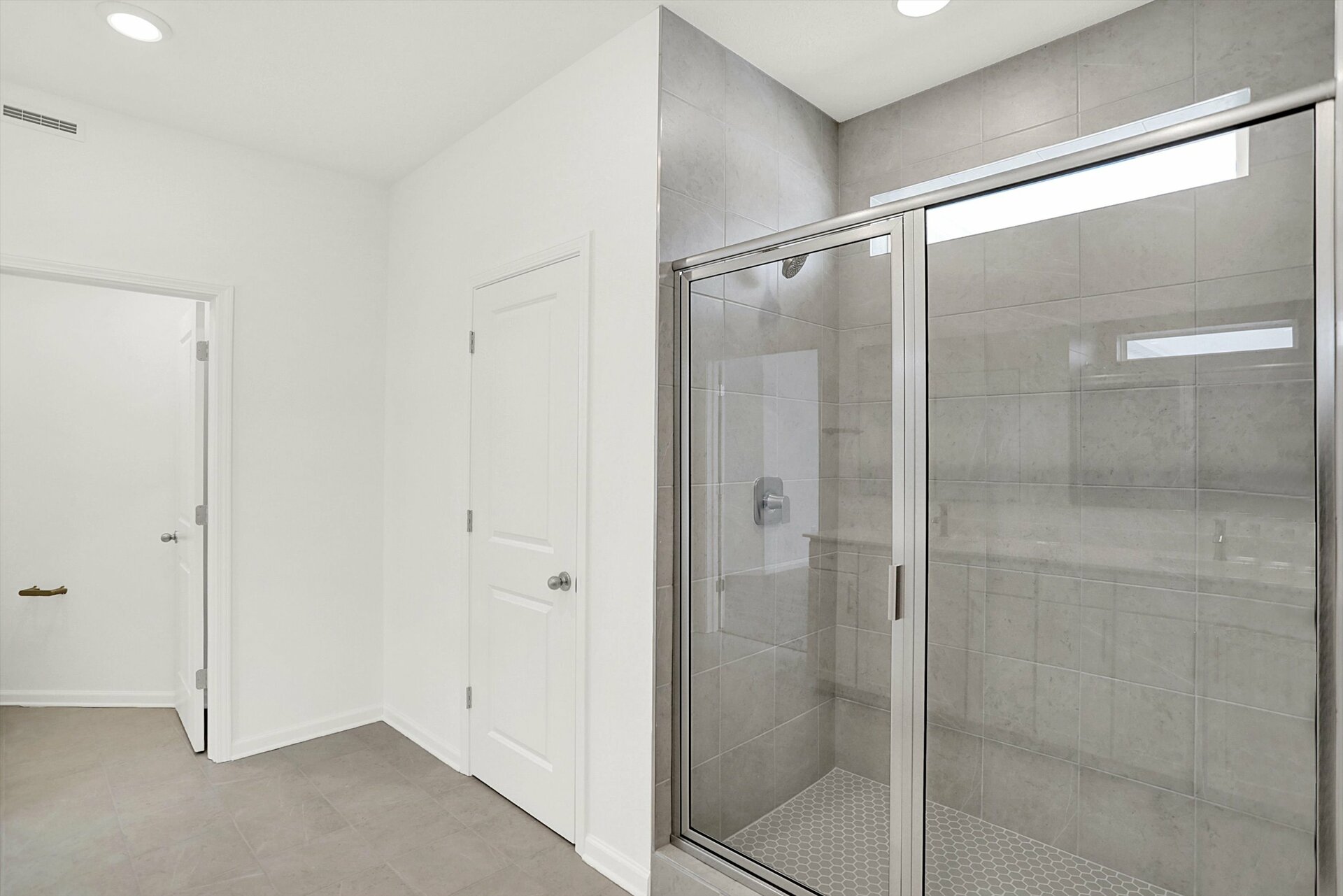 bathroom with walk-in tile shower and transom window