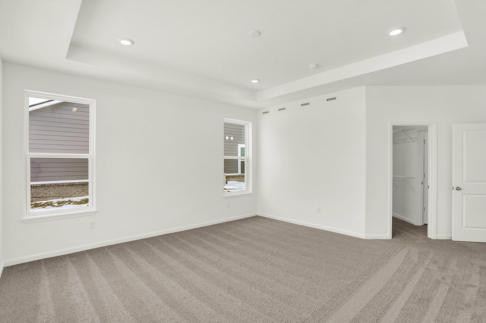 bedroom with tray ceiling and gray carpet