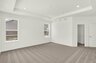 bedroom with tray ceiling and gray carpet