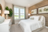 primary bedroom with king-sized white bed and wooden accent wall