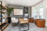 at-home office with leather barrel chairs and wooden display shelf