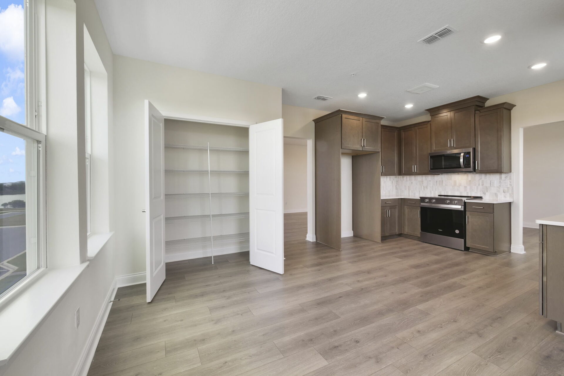 room with hardwood floors, large windows and storage