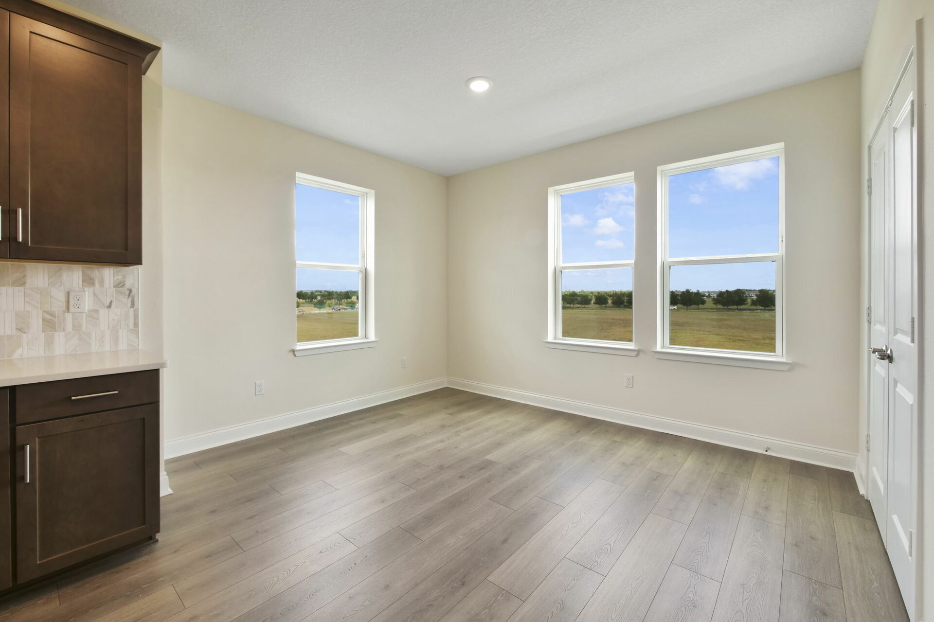 room with hardwood floors, large windows and storage