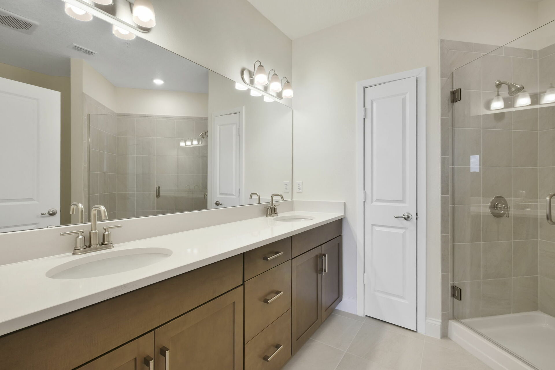 dual sink vanity with oversized shower with seating