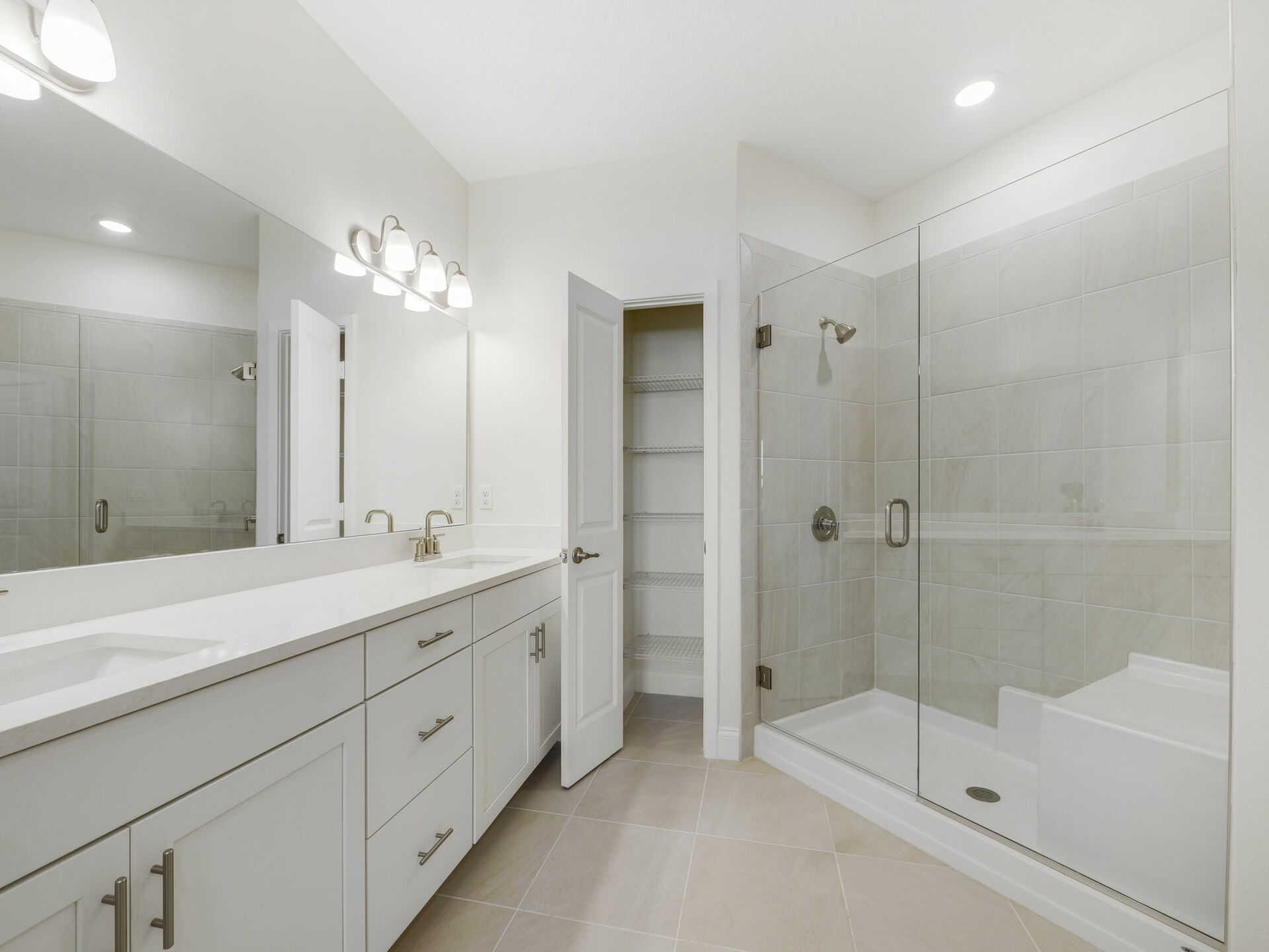 dual sink vanity, water closet, and semi-frameless shower