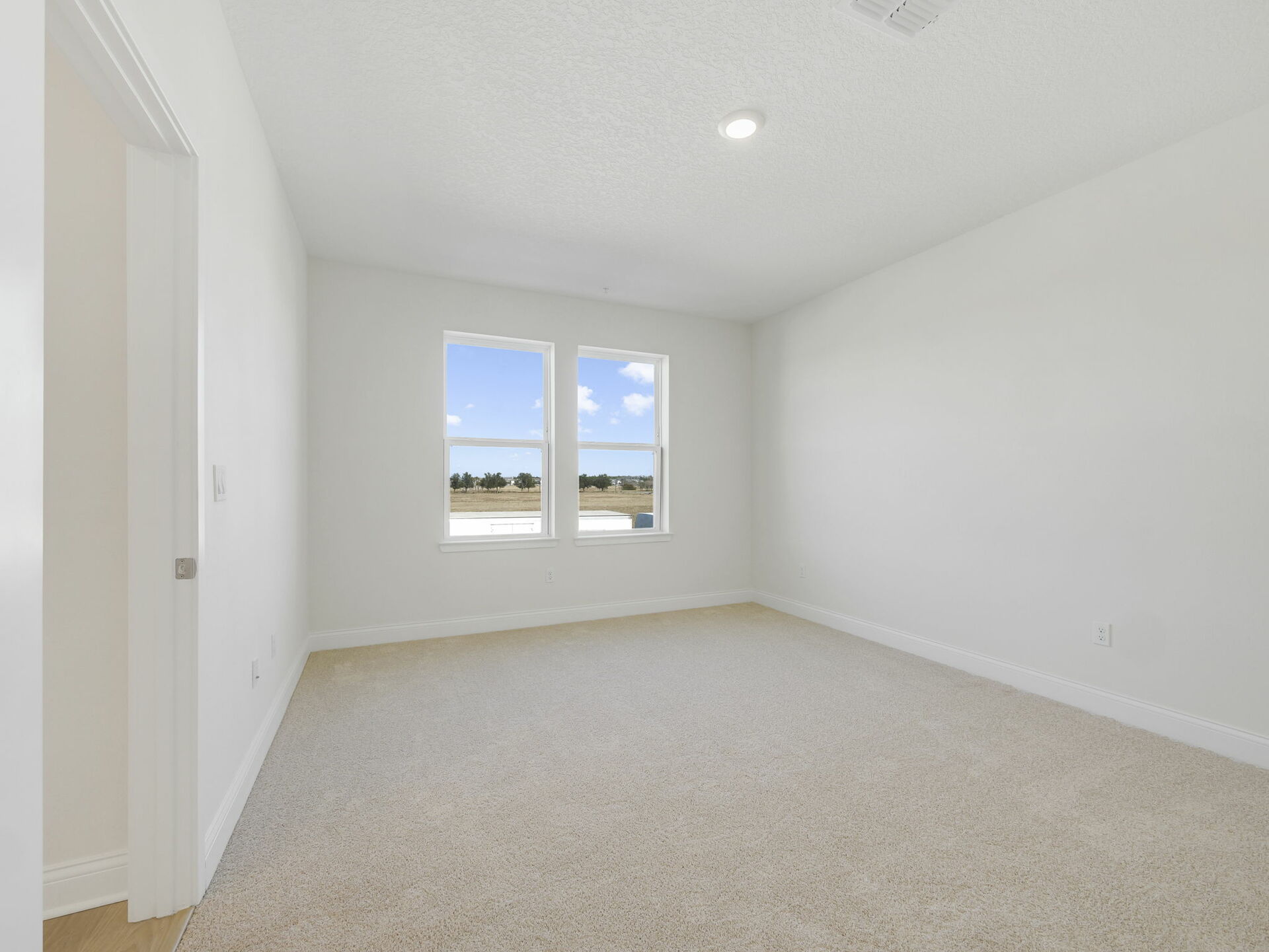 bedroom with carpet, large windows and access to primary bathroom 