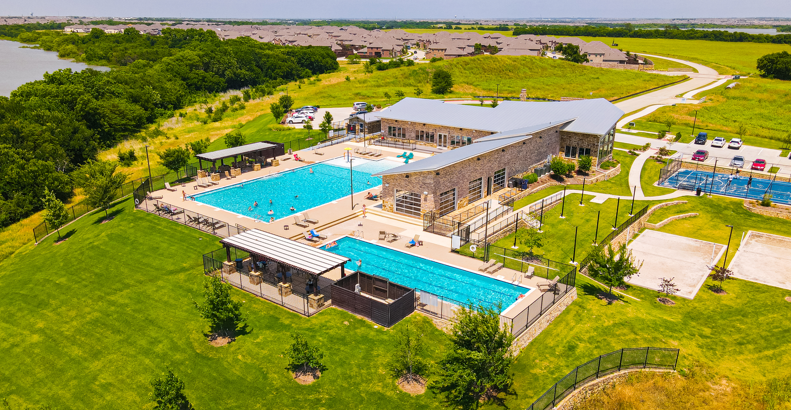 beautiful pool next to a large amenity center