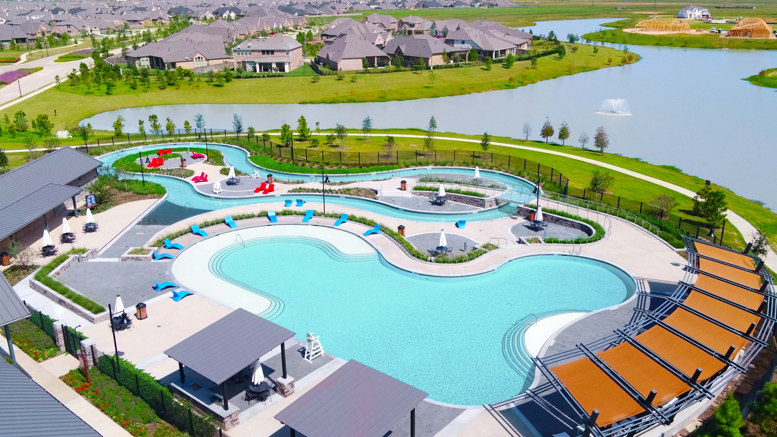 community pool with lazy river and lounge chairs 