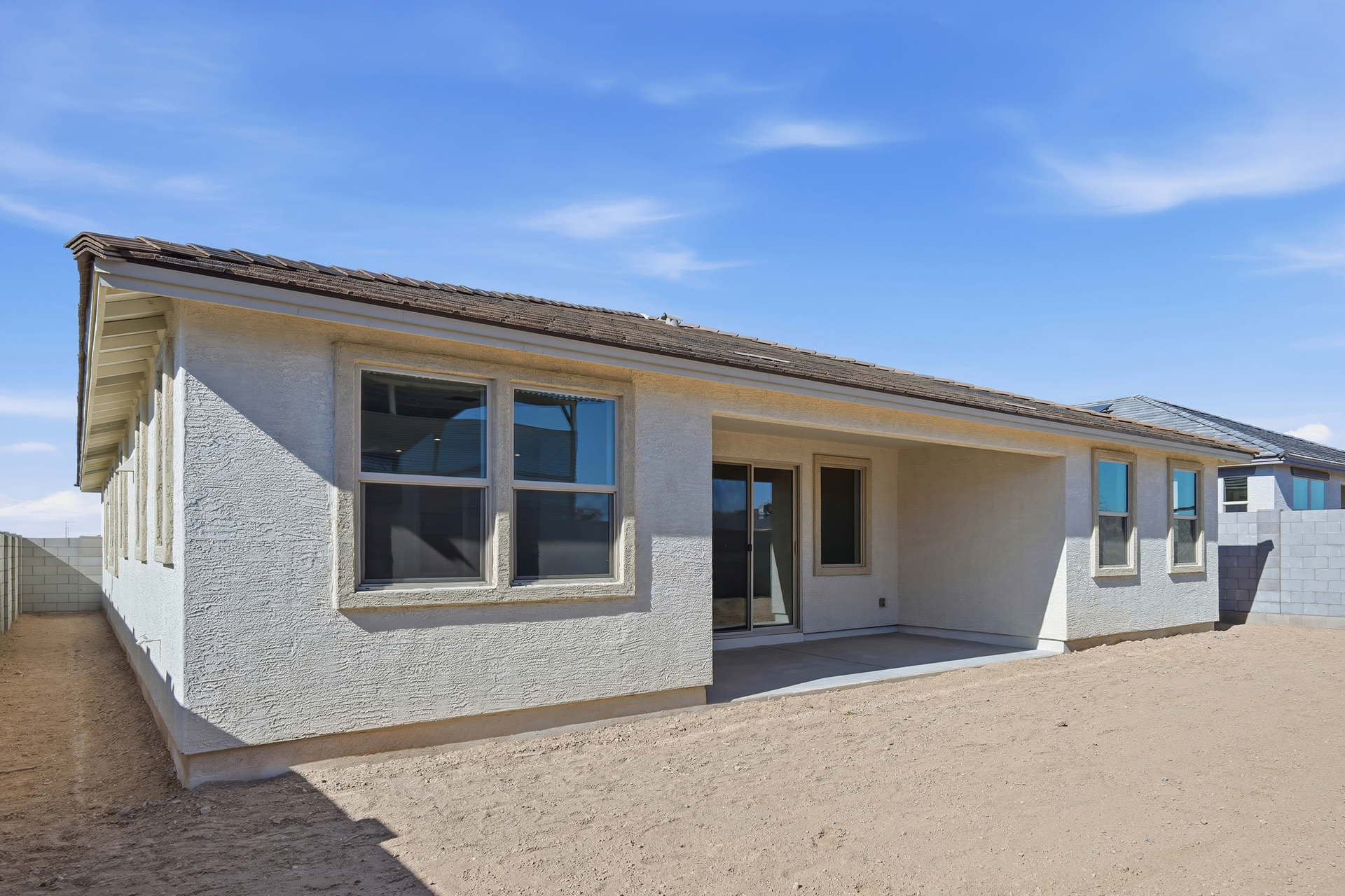 spacious dirt backyard with covered patio