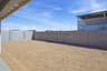 spacious dirt backyard with a concrete block wall