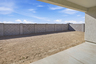 spacious dirt backyard with concrete block wall