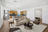 open-concept space with a large white couch, dark brown wooden coffee table, and dark green accent chair