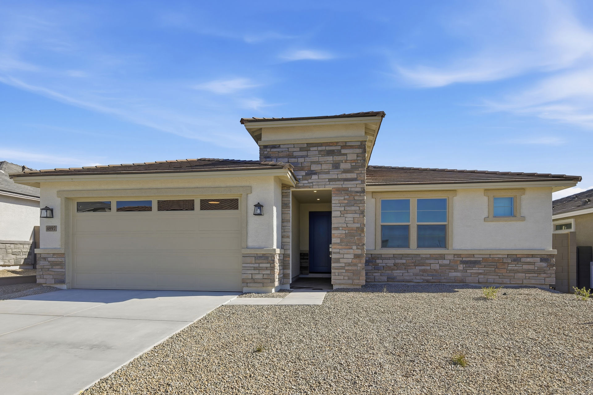 single-story single-family home with desert landscaping and concrete driveway