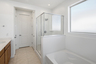 bathroom with a walk-in shower and soaking tub